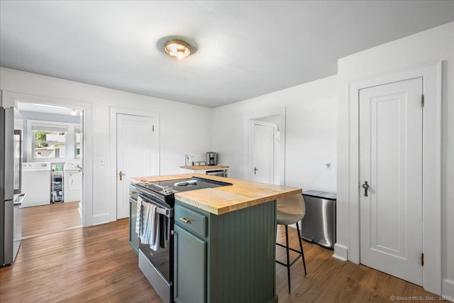 17 Wild Rose Pl, Waterford, CT 06385 - kitchen with stainless steel appliances, butcher block counters, a breakfast bar area, wood finished floors, and a kitchen island