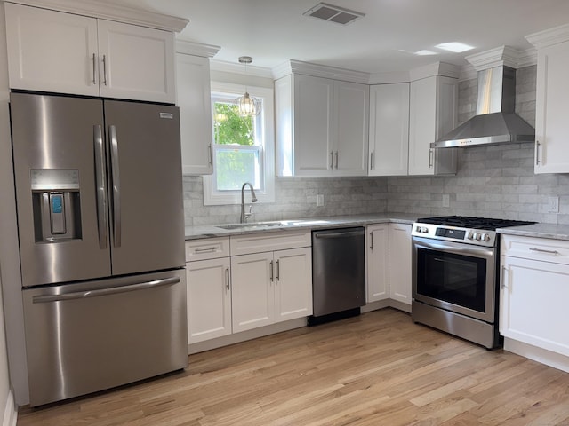 42 Waldo St, East Haven, CT 06512 - kitchen featuring appliances with stainless steel finishes, wall chimney exhaust hood, a sink, light wood-type flooring, and white cabinetry