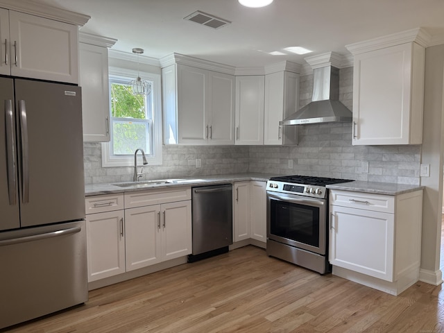42 Waldo St, East Haven, CT 06512 - kitchen with stainless steel appliances, wall chimney exhaust hood, a sink, white cabinets, and light wood-type flooring