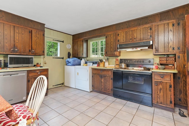 12 Lords Hwy E, Weston, CT 06883 - kitchen featuring stainless steel appliances, under cabinet range hood, washing machine and clothes dryer, wood walls, and light countertops