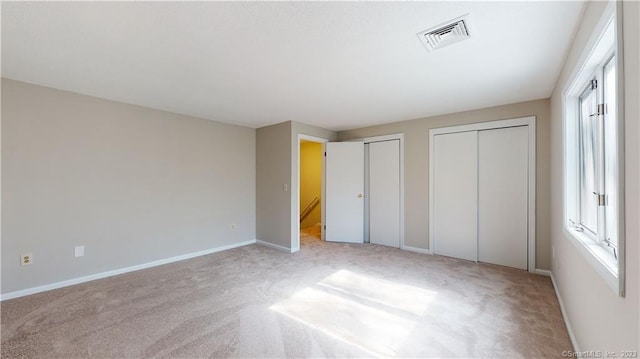 12 Cardinal Dr Unit 12, Farmington, CT 06032 - unfurnished bedroom featuring multiple closets, light carpet, and baseboards