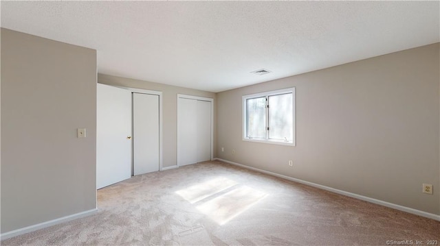 12 Cardinal Dr Unit 12, Farmington, CT 06032 - unfurnished bedroom featuring multiple closets, carpet flooring, and baseboards