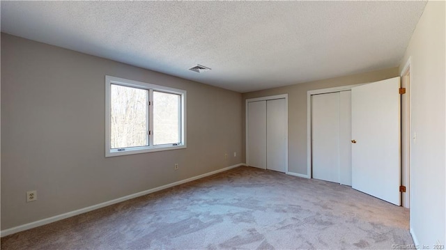 12 Cardinal Dr Unit 12, Farmington, CT 06032 - unfurnished bedroom with two closets, carpet floors, a textured ceiling, and baseboards