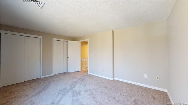 12 Cardinal Dr Unit 12, Farmington, CT 06032 - unfurnished bedroom featuring carpet floors, two closets, and baseboards
