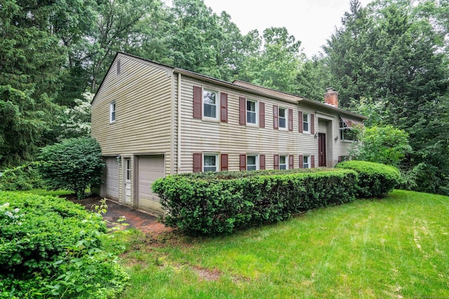 35 Chestnut Hill Rd, Simsbury, CT 06092 - split foyer home featuring a chimney, a garage, a front lawn, and view of wooded area