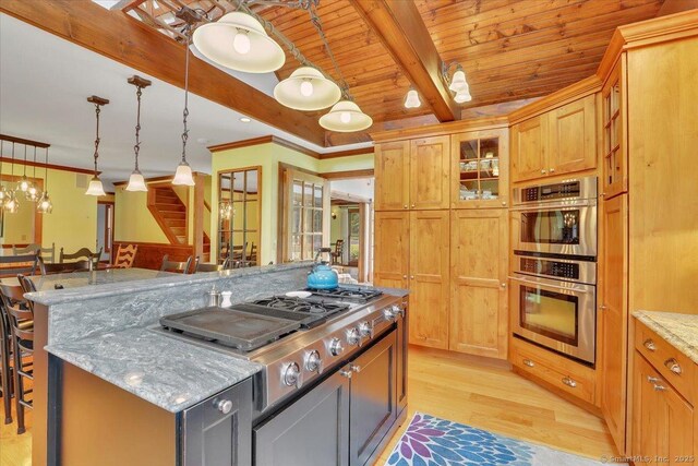 45 Snell Rd, Middlefield, CT 06422 - kitchen featuring appliances with stainless steel finishes, a breakfast bar, light wood-type flooring, a kitchen island, and light stone counters