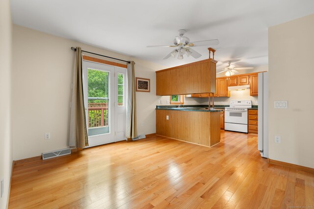42 Cindy Ln, Groton, CT 06355 - kitchen with white electric range, a peninsula, ceiling fan, dark countertops, and light wood-type flooring