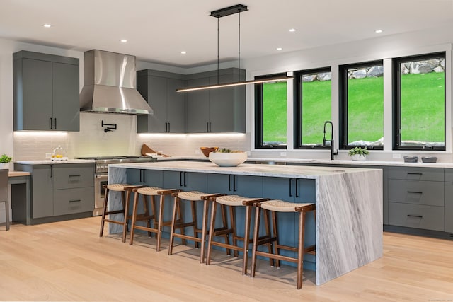 22 Limekiln Rd, Redding, CT 06896 - kitchen with wall chimney exhaust hood, gray cabinetry, double oven range, modern cabinets, and light wood-type flooring