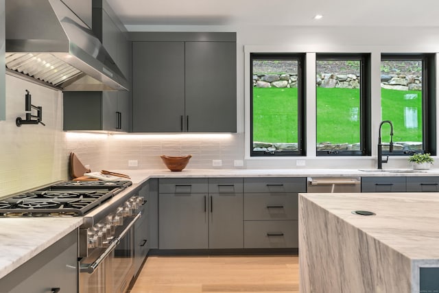 22 Limekiln Rd, Redding, CT 06896 - kitchen featuring gray cabinetry, wall chimney exhaust hood, a sink, stainless steel appliances, and decorative backsplash