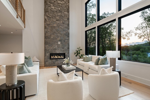22 Limekiln Rd, Redding, CT 06896 - living area featuring a towering ceiling, wood finished floors, plenty of natural light, a stone fireplace, and baseboards