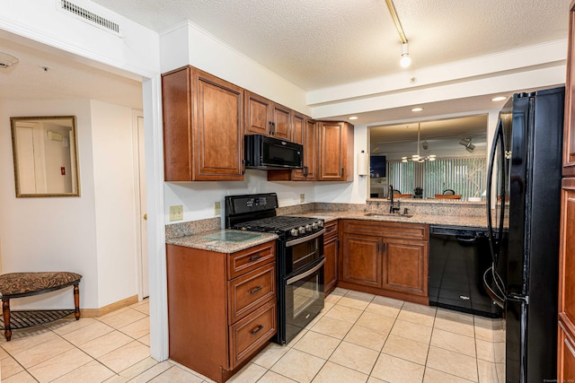 2 Mansfield Grove Rd Apt 160, East Haven, CT 06512 - kitchen featuring black appliances, a sink, brown cabinets, light tile patterned floors, and a textured ceiling