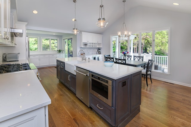 156 Main St, Ridgefield, CT 06877 - kitchen featuring a sink, stainless steel dishwasher, white cabinetry, vaulted ceiling, and a chandelier