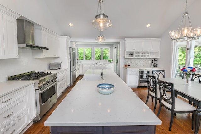 156 Main St, Ridgefield, CT 06877 - kitchen with wall chimney exhaust hood, appliances with stainless steel finishes, a sink, wine cooler, and lofted ceiling
