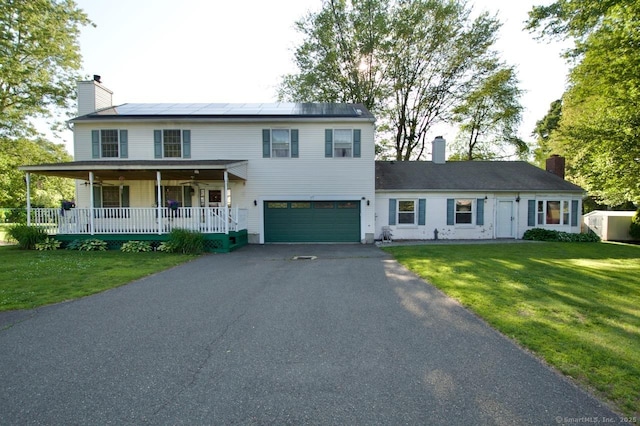 77 Bassett Rd, North Haven, CT 06473 - view of front of property featuring a porch, an attached garage, driveway, a chimney, and solar panels