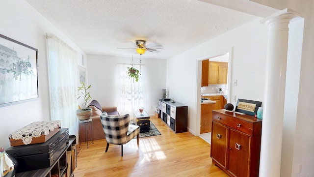 77 Bassett Rd, North Haven, CT 06473 - living area with a ceiling fan, light wood finished floors, decorative columns, and a textured ceiling