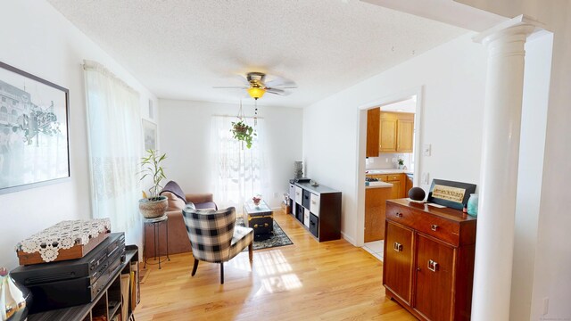 77 Bassett Rd, North Haven, CT 06473 - living area with a ceiling fan, light wood finished floors, decorative columns, and a textured ceiling