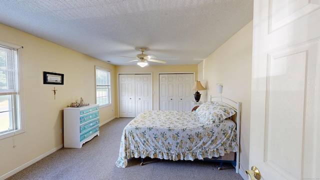 77 Bassett Rd, North Haven, CT 06473 - carpeted bedroom featuring two closets, baseboards, a textured ceiling, and ceiling fan