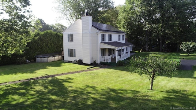77 Bassett Rd, North Haven, CT 06473 - view of front of home with covered porch, a chimney, a covered pool, a front lawn, and roof with shingles