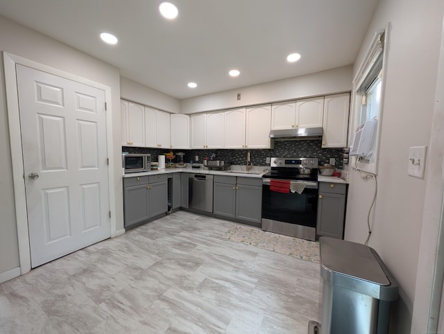 94 Canterbury Rd Unit D, Plainfield, CT 06374 - kitchen featuring appliances with stainless steel finishes, gray cabinets, under cabinet range hood, a sink, and backsplash