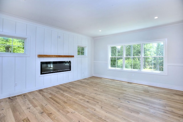 59 Thornhill Rd, Fairfield, CT 06824 - unfurnished living room featuring crown molding, a glass covered fireplace, plenty of natural light, light wood-type flooring, and baseboards