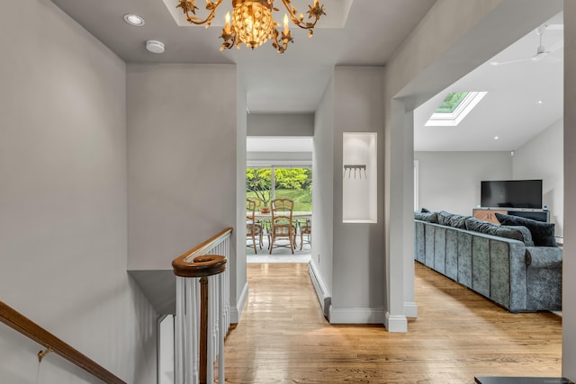 15 Hallsey Ln, Woodbridge, CT 06525 - corridor with light wood-style floors, a skylight, a chandelier, a baseboard heating unit, and recessed lighting