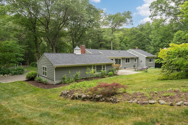15 Hallsey Ln, Woodbridge, CT 06525 - back of house with a patio, a yard, roof with shingles, a chimney, and a wooded view