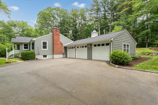 15 Hallsey Ln, Woodbridge, CT 06525 - view of property exterior featuring view of wooded area, a chimney, a shingled roof, and a garage