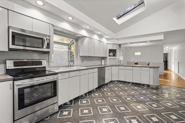 7 Lorma Ave, Trumbull, CT 06611 - kitchen with stainless steel appliances, a peninsula, a sink, white cabinets, and recessed lighting