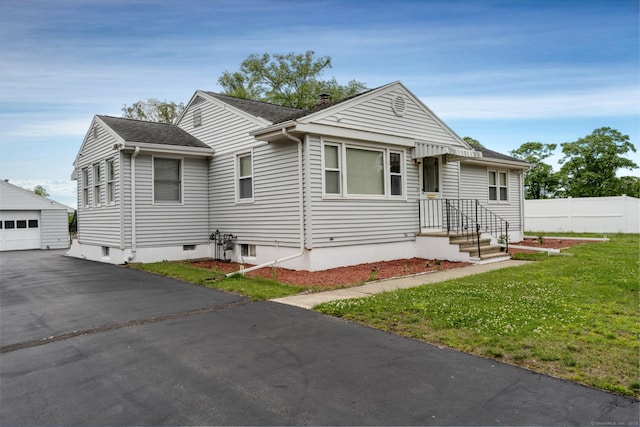 34 River St, East Haven, CT 06512 - bungalow-style home featuring an outdoor structure, a detached garage, a shingled roof, and driveway