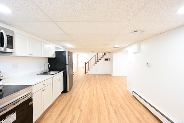34 River St, East Haven, CT 06512 - kitchen with stainless steel appliances, a baseboard radiator, a paneled ceiling, white cabinetry, and a sink