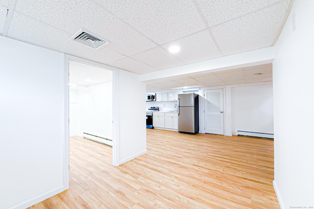 34 River St, East Haven, CT 06512 - kitchen with stainless steel appliances, a baseboard heating unit, baseboard heating, a paneled ceiling, and white cabinets