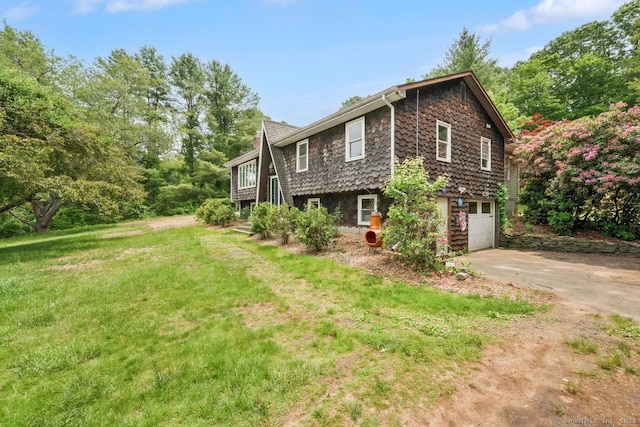 18 Robbie Rd, East Haddam, CT 06469 - view of side of home with concrete driveway, a garage, and a lawn
