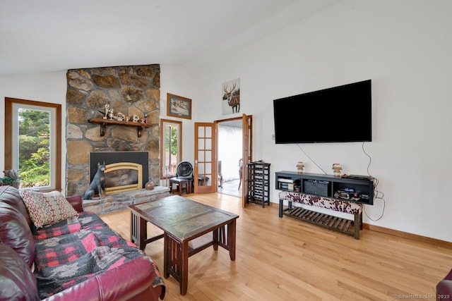 18 Robbie Rd, East Haddam, CT 06469 - living area with vaulted ceiling, light wood-style flooring, a stone fireplace, and baseboards