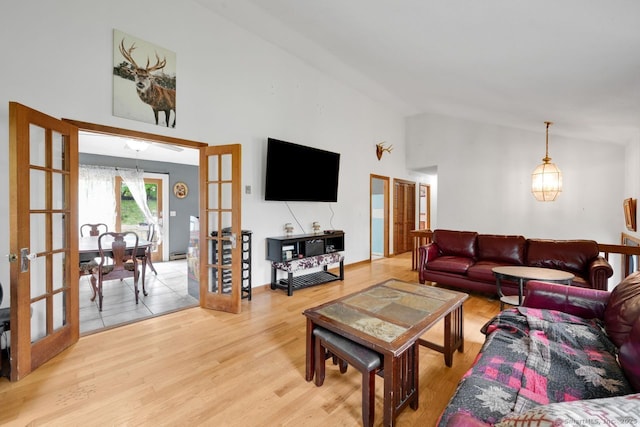 18 Robbie Rd, East Haddam, CT 06469 - living room featuring french doors, light wood finished floors, high vaulted ceiling, a chandelier, and a baseboard heating unit