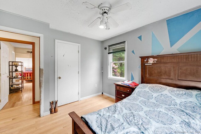 18 Robbie Rd, East Haddam, CT 06469 - bedroom with light wood-style flooring, a textured ceiling, a ceiling fan, and baseboards