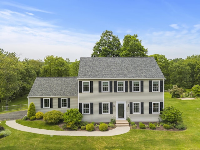 colonial inspired home featuring a shingled roof