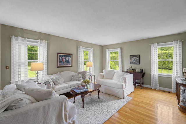 living area featuring light wood finished floors and baseboards