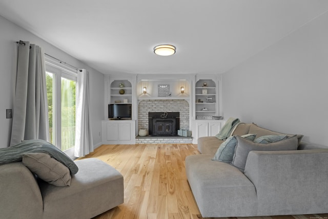 living room featuring light wood-style floors and built in shelves