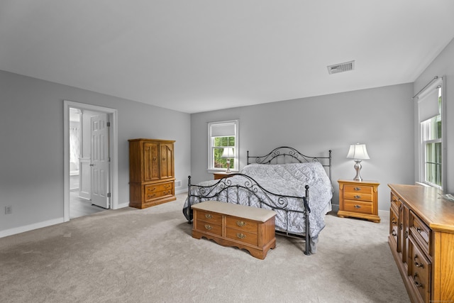 carpeted bedroom with baseboards and ensuite bathroom