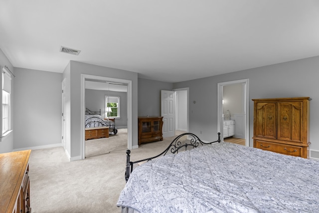 bedroom with light carpet, a closet, and baseboards