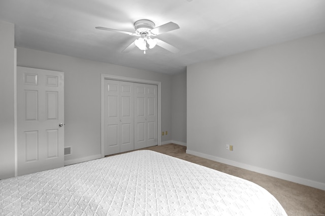 unfurnished bedroom featuring carpet floors, baseboards, a closet, and a ceiling fan