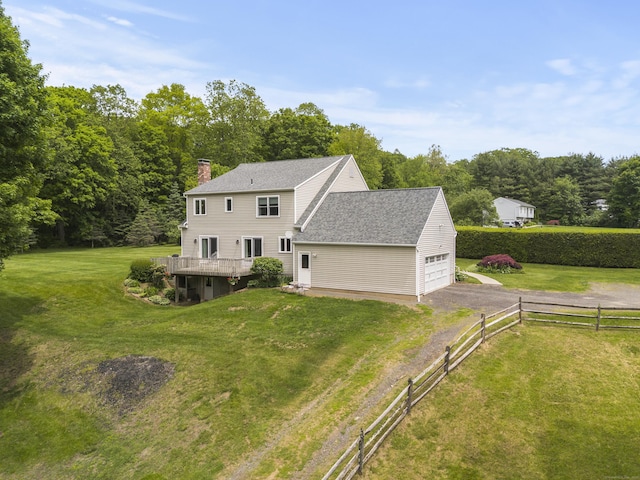 view of front of house with a chimney, asphalt driveway, a garage, a shingled roof, and a wooden deck