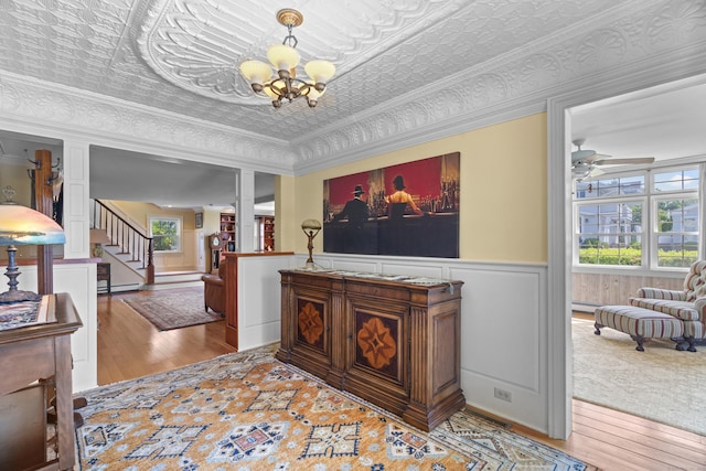 5 Oakwood Rd, Old Saybrook, CT 06475 - living room with wood finished floors, a chandelier, a ceiling fan, a wainscoted wall, and stairs
