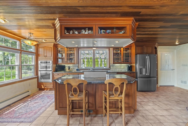 5 Oakwood Rd, Old Saybrook, CT 06475 - kitchen featuring stainless steel appliances, wooden ceiling, baseboard heating, a center island, and brown cabinets