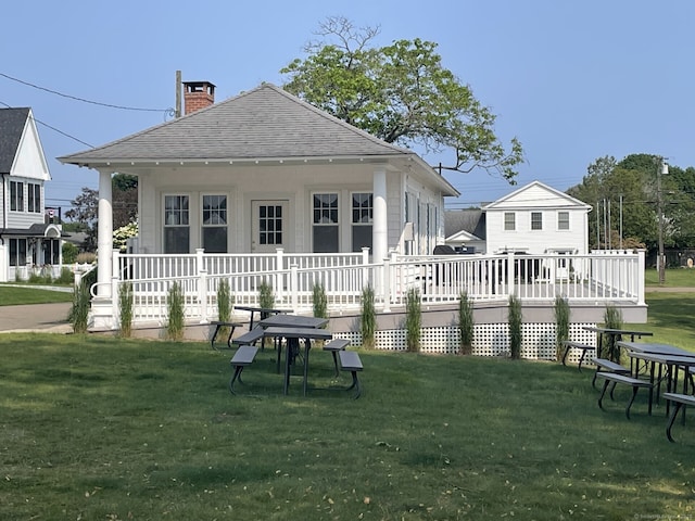 5 Oakwood Rd, Old Saybrook, CT 06475 - rear view of house with a shingled roof, a lawn, and a chimney