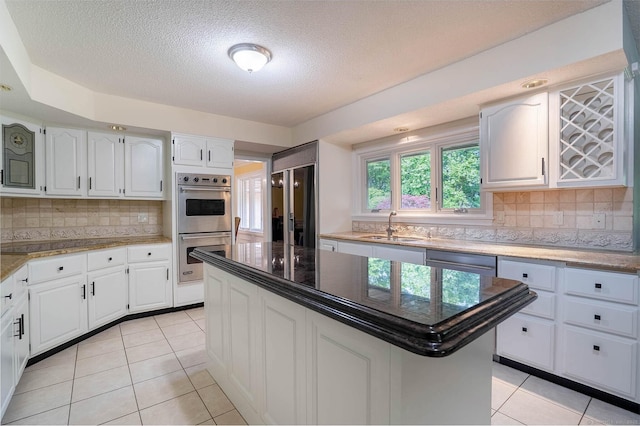 70R Tri Mountain Rd, Durham, CT 06422 - kitchen featuring appliances with stainless steel finishes, a sink, light tile patterned floors, tasteful backsplash, and a textured ceiling