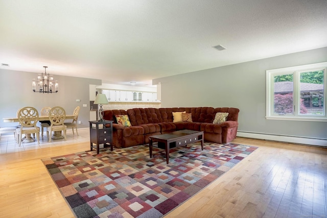 70R Tri Mountain Rd, Durham, CT 06422 - living area featuring a baseboard radiator, a chandelier, and light wood finished floors