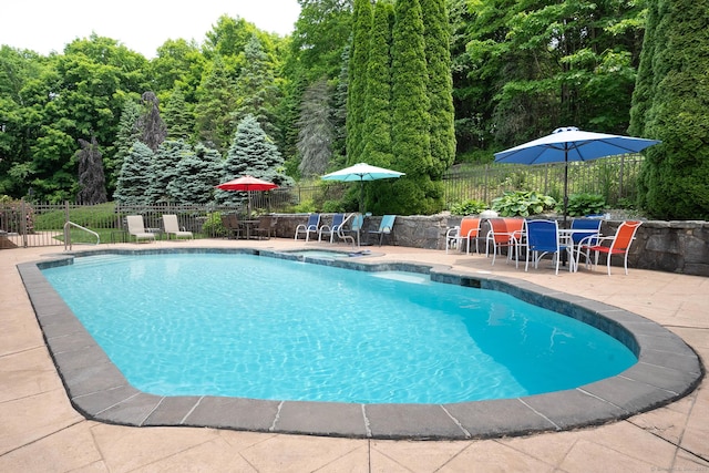 70R Tri Mountain Rd, Durham, CT 06422 - view of swimming pool featuring outdoor dining area, a patio, a pool with connected hot tub, and a forest view