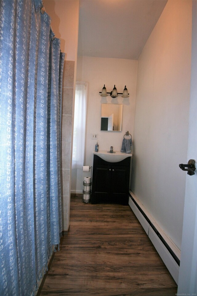 72 Brooker St, Torrington, CT 06790 - full bathroom with a baseboard radiator, wood finished floors, vanity, and a shower with shower curtain