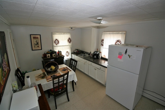 72 Brooker St, Torrington, CT 06790 - kitchen featuring freestanding refrigerator, crown molding, a baseboard heating unit, a sink, and white cabinetry